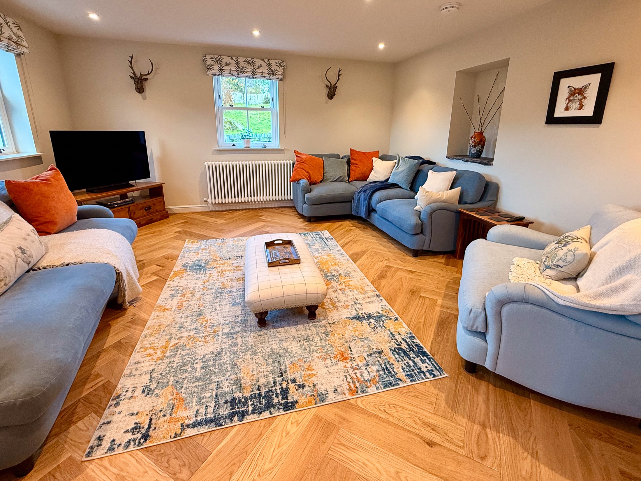 Cosy lounge with sofas and warm wood flooring